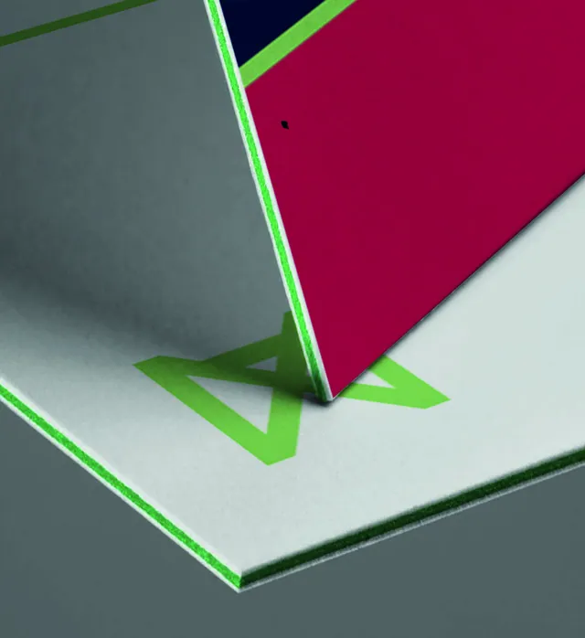Close-up of a Navix business card standing on its edge: a green core shows between the white layers, with a large Brand Green logomark on the surface below.